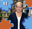 Joanne, Our Circulation Specialist, Poses In Front Of Books, Surrounded By Orange And Blue Flowers.