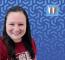 Uniontown Branch Manager, Katie, Poses In Front Of A Blue Gradient Spiral Background.